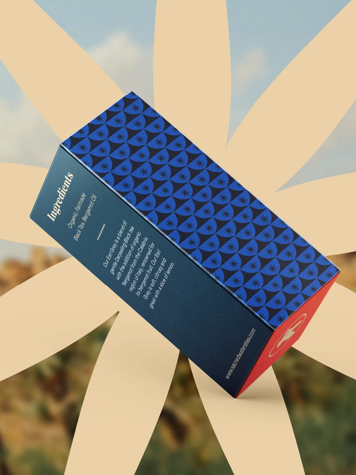 Side of an Earl Grey box with a blue pattern and ingredients, against a large stylized flower
